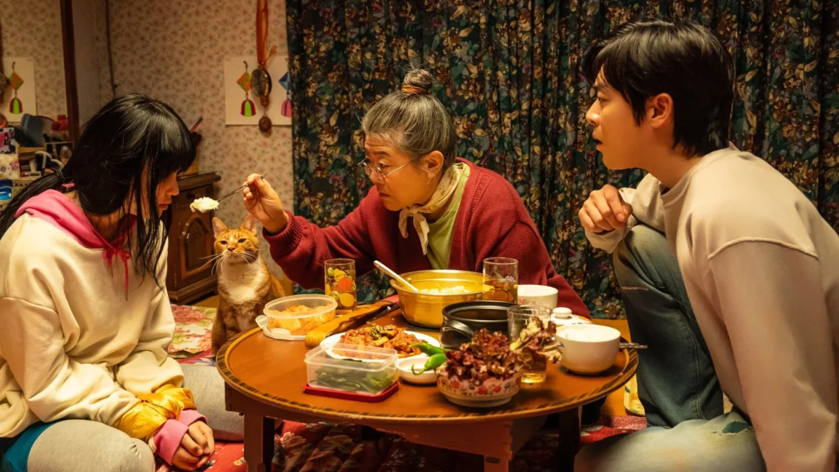 Foto do filme, com a avó Bam-sun dando comida para a neta zumbi, Soo-ah.